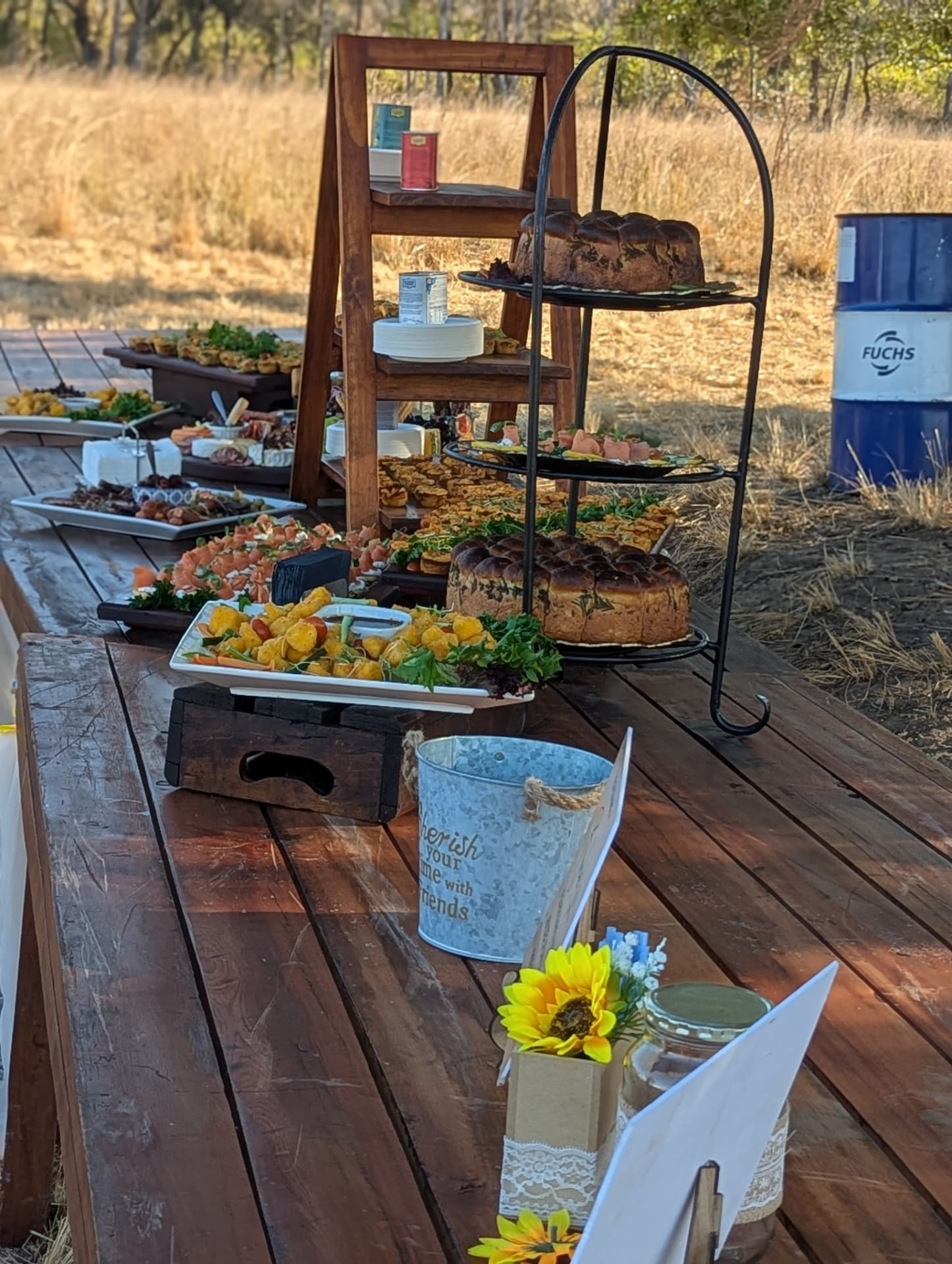 Rustic outdoor buffet table with breads, tarts and canapés in the bush