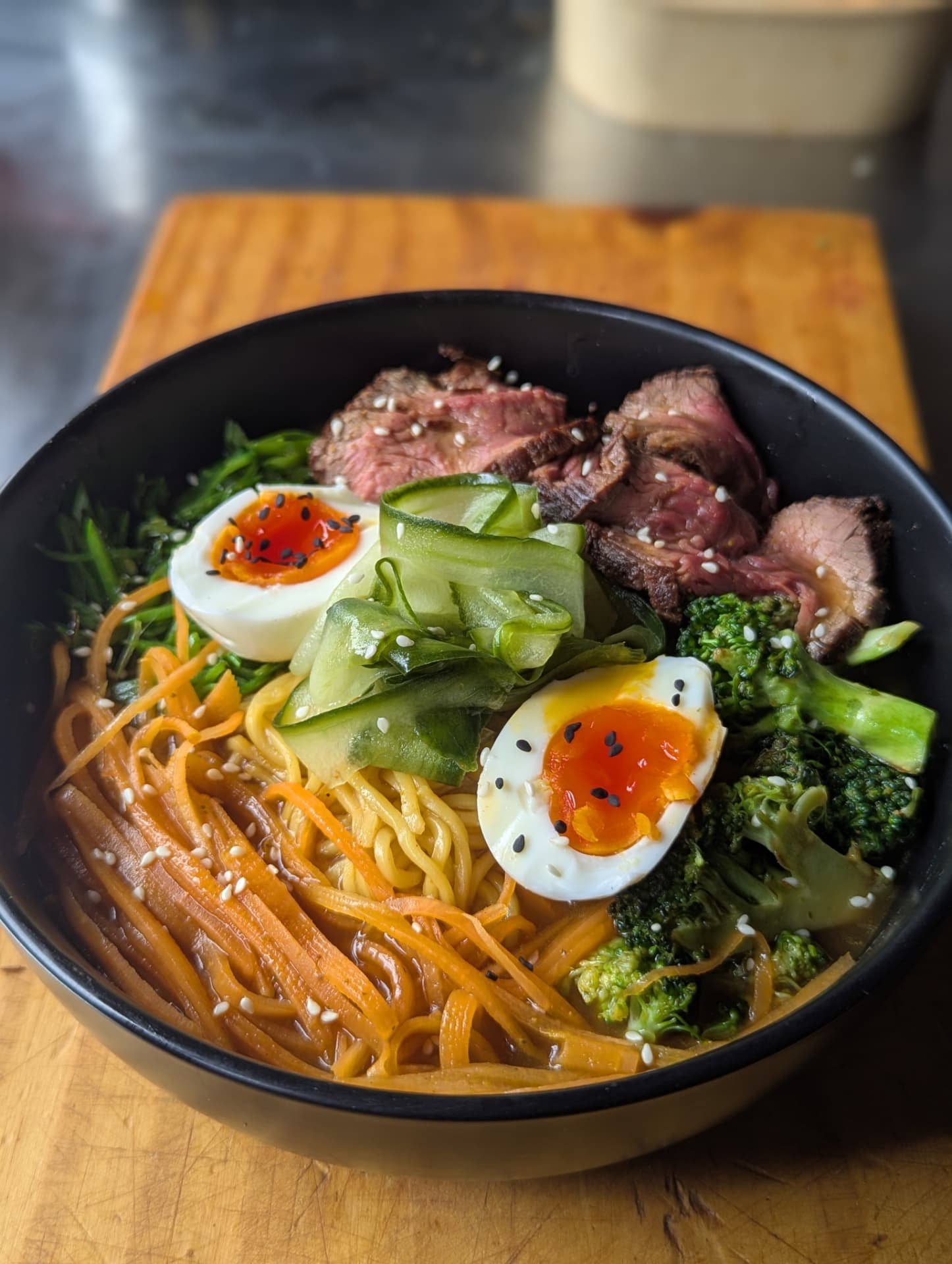 Ramen bowl with seared steak, soft-boiled eggs and fresh vegetables