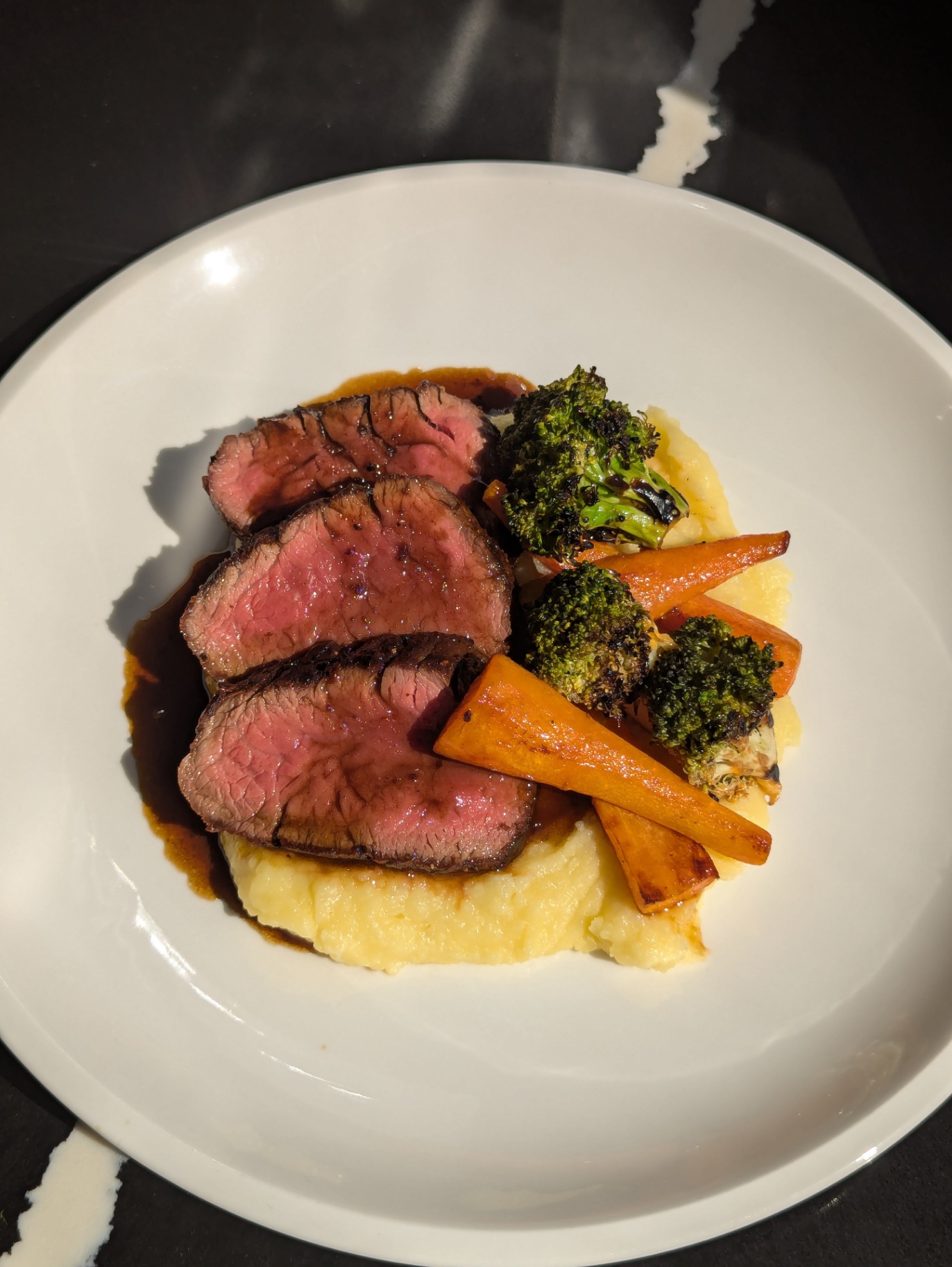 Pink-centred beef with mash, roasted carrots and charred broccoli